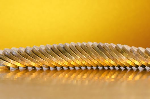 A number of coins lying on the Golden surface with a Golden background