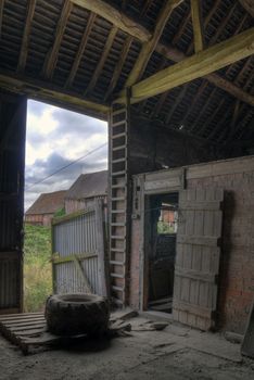Timber-frame and brick hay barn interior, Warwickshire, England.
