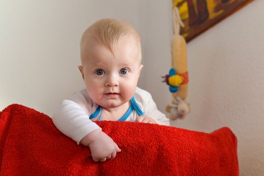 Portrait of a six month old baby boy looking curious at the camera