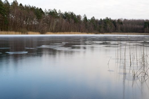 A frozen lake in Denmark on a cold winter day without snow