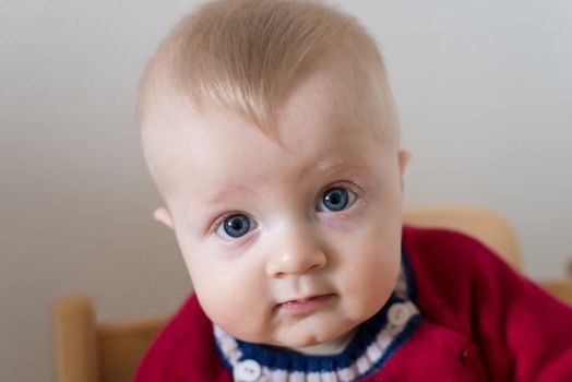 Portrait of a six month old baby boy looking curious at the camera