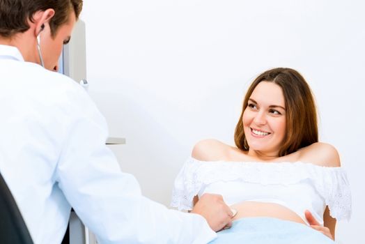 Young attractive pregnant woman on reception at the doctor, health check