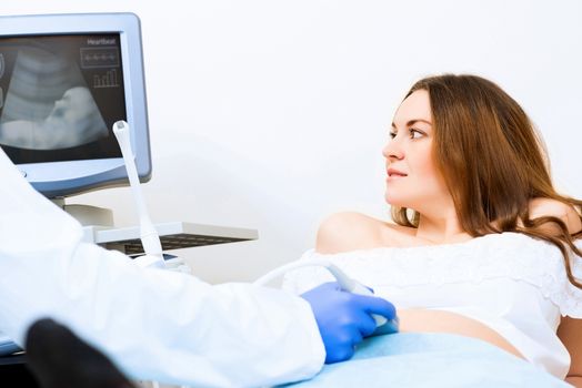 Young attractive pregnant woman on reception at the doctor, health check