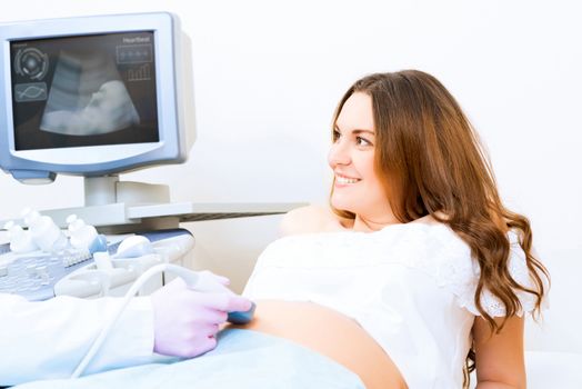 Young attractive pregnant woman on reception at the doctor, health check