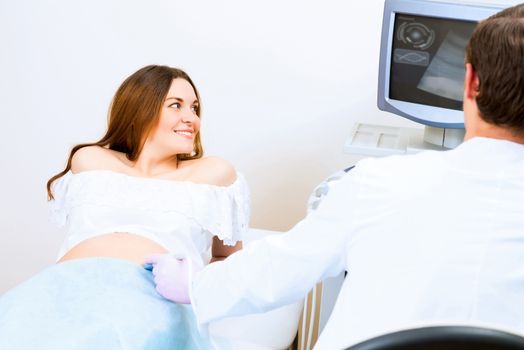 Young attractive pregnant woman on reception at the doctor, health check