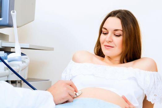 Young attractive pregnant woman on reception at the doctor, health check