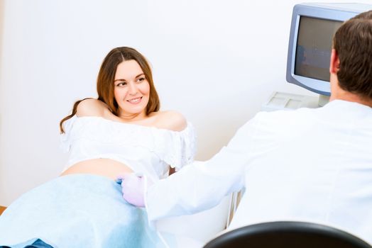 Young attractive pregnant woman on reception at the doctor, health check