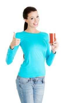 Happy smiling woman drinking tomato juice and gesturing OK