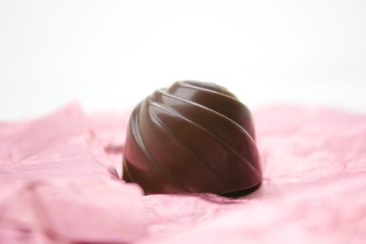 Chocolate candy on a pink wrapping.