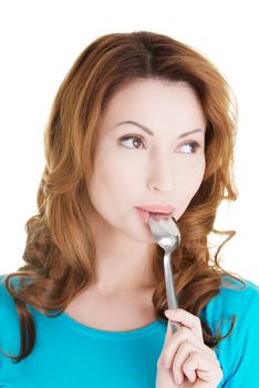 Portrait of smiling woman with spoon in her mouth and (pleasure from eating), isolated on white