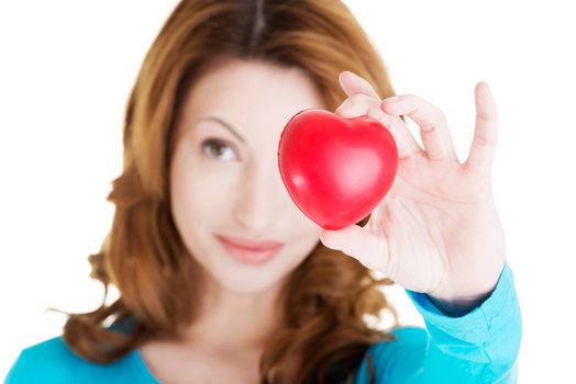 Attractive smiling woman showing red heart toy