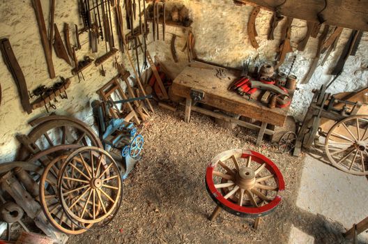 Traditional wheelwrights workshop with tools and cartwheels, England.