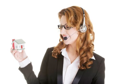 Attractive call center support woman with headset andhouse model in hands. Real estate concept.