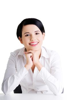 Young beautiful businesswoman behind the desk, isolated