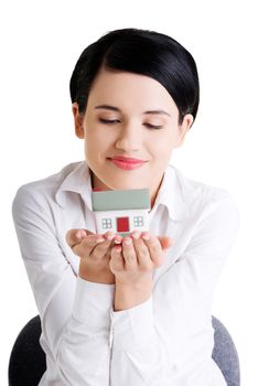 Female businesswoman hands holding and protecting house. Home protecting concept for insurance or security