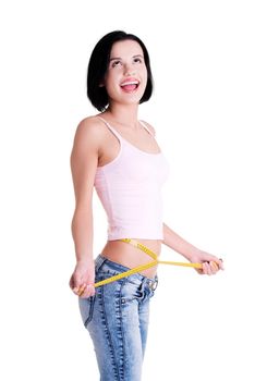 Happy young woman measuring her waist and looking up on copy space