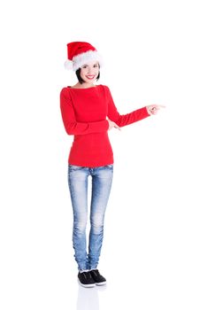 Beautiful smiling christmas santa woman pointing on side showing copyspace. Isolated on white background.