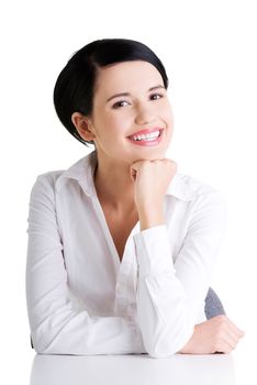 Young beautiful happy businesswoman behind the desk, isolated