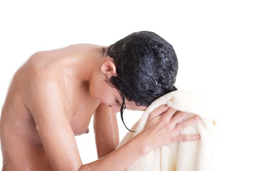 A young woman with wet hair in white robe toweling off after a shower.