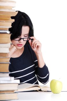 Young student woman with books studying at the desk, isolated on white background