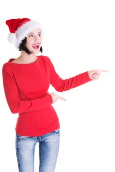 Beautiful smiling christmas santa woman pointing on side showing copyspace. Isolated on white background.