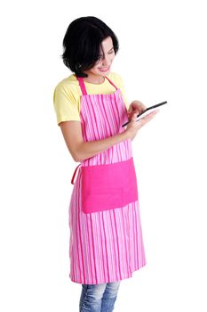 Young woman in pink apron using tablet computer, isolated