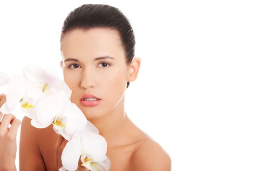 Portrait of beautiful young woman with health skin and with orchid flower