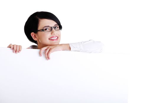 Smiling young business woman showing blank signboard, over white background isolated