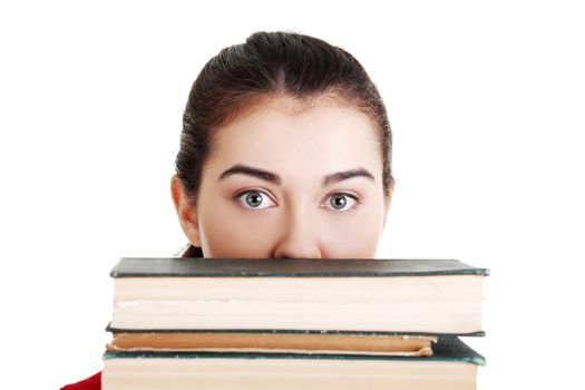 Young woman behind an old books, isolated on white