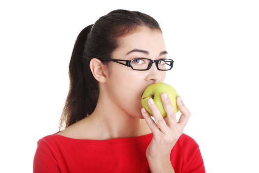 Attractive young woman eating green apple. Isolated