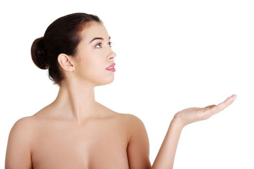 Attractive woman with clean fresh skin presenting copy space on her palm