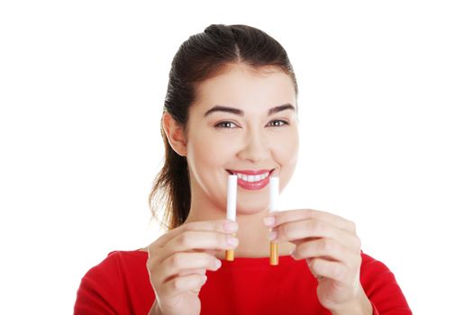 Young woman holding in one hand classic cigarette and in other electronic cigarette