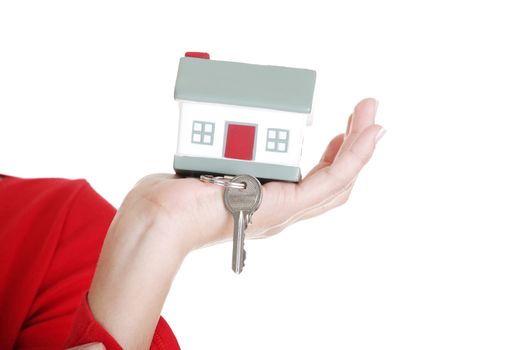 Hand holding a house key. Isolated on white background.