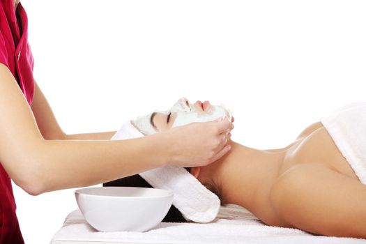 Beauty treatment in spa salon. Woman with facial clay mask.