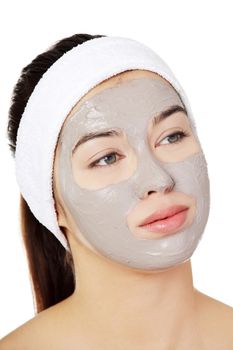 Beautiful woman with clay facial mask, isolated on white