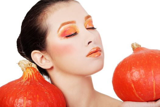 Beautiful woman with orange make up holding pumpkin. Isolated on white
