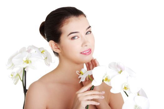 Portrait of beautiful young woman with health skin and with orchid flower