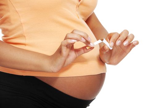 Pregnant woman breaking a cigarette - stop smoking concept