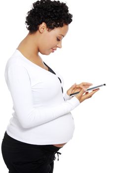 Pregnant woman relaxing with a computer tablet , isolated on white