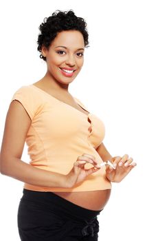 Pregnant woman breaking a cigarette - stop smoking concept