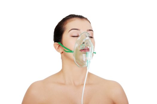 Diseased female patient wearing a oxygen mask against white background