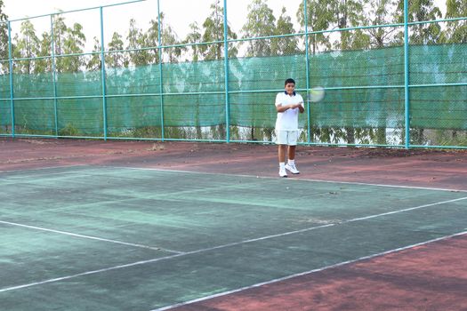 Thai young tennis player hit the tennis ball