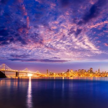 San Francisco sunset skyline and Bay Bridge in California with reflection in bay water USA