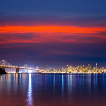 San Francisco sunset skyline and Bay Bridge in California with reflection in bay water USA