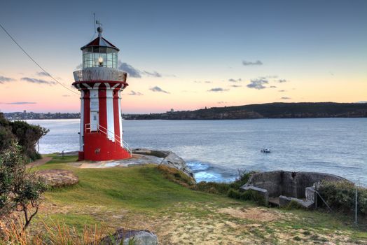 The beautiful red and white Hornby Lighthouse on South Head, Sydney Australia, the entrance to Sydney Harbour, at dawn.