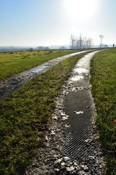 A wet farm track makes its way across an English field.
