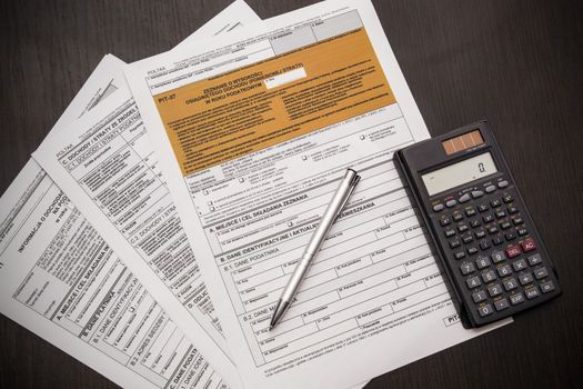 Polish tax form with pen and calculator on desk