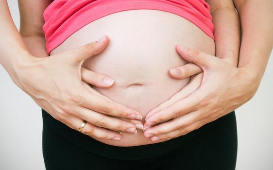 Husband hands on pregnant woman belly