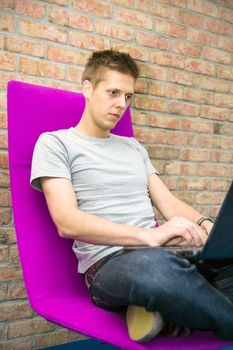 Man sitting in chair and working with laptop