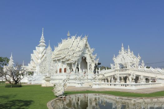 CHIANG RAI, THAILAND - JANUARY 10: Wat Rong Koon Temple on January 10, 2013 in Chiang Rai province, Northern Thailand, Wat Rong Koon Temple is a modern temple built since 1998 by Thai artist Chalermchai Kositpipat.